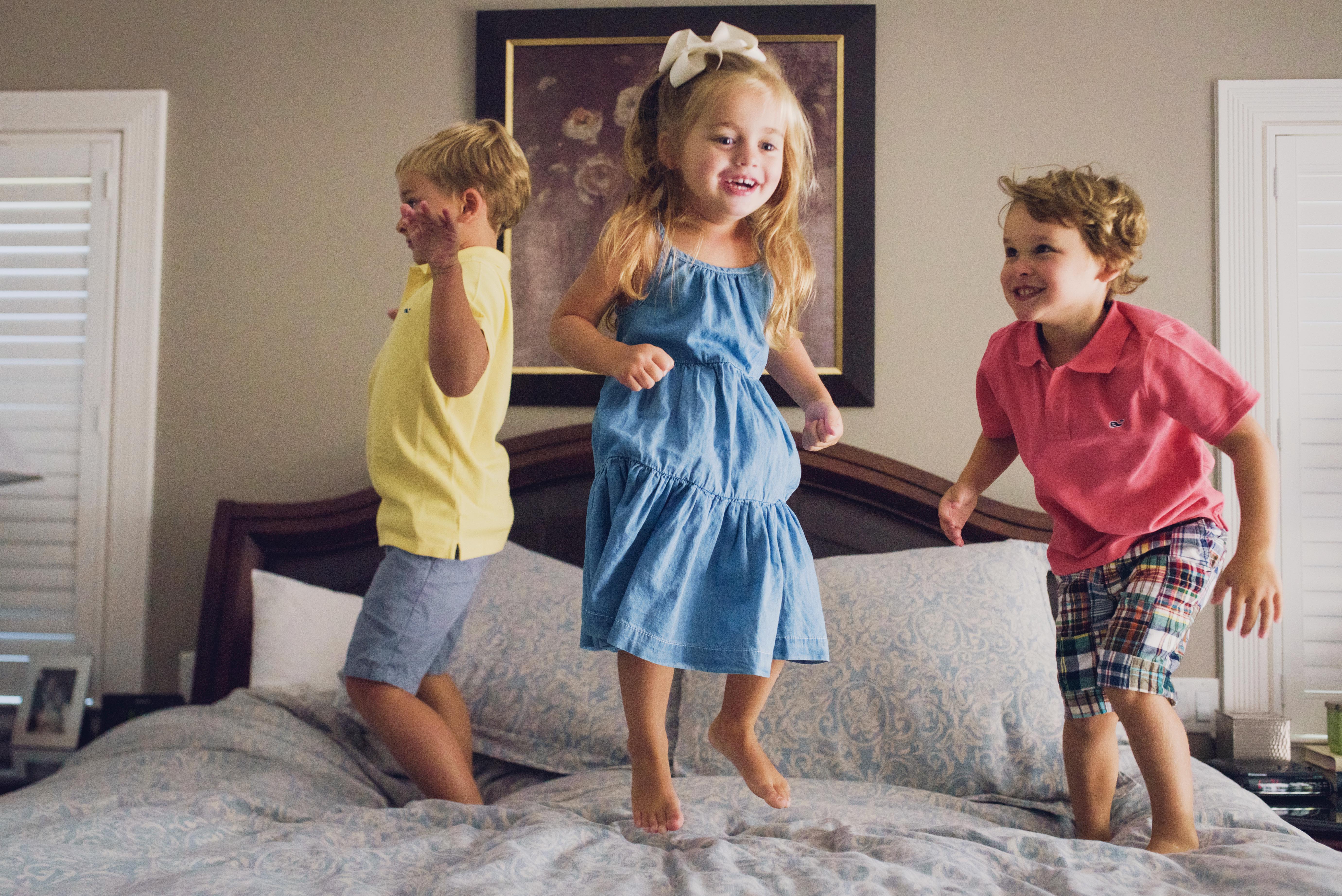children-jumping-on-bed-for-photo-shoot-in-sacramento-home