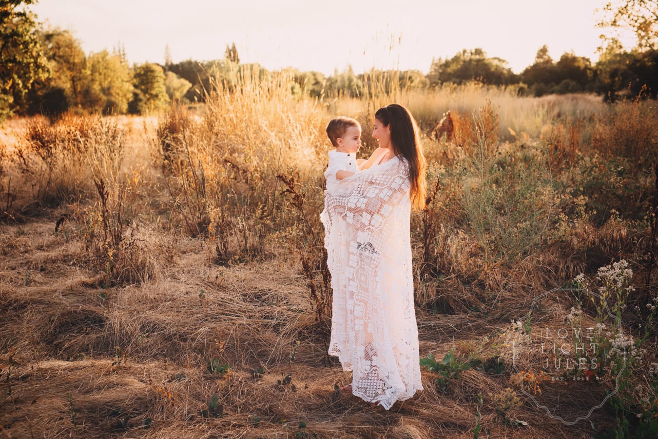mom-and-son-wrapped-in-blanket-for-photo-session-at-dusk-in-sacramento-park