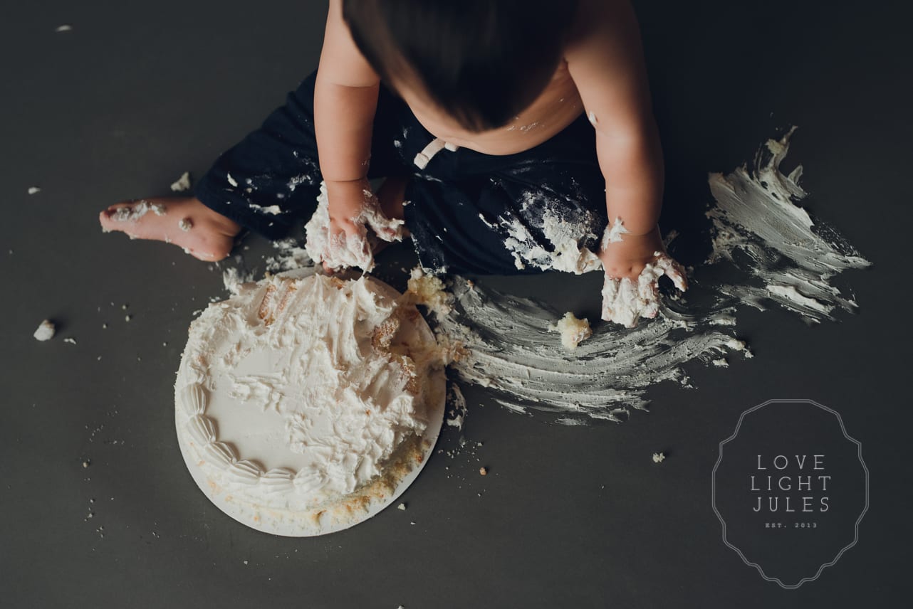 cake-smash-wiping-frosting-across-floor-at-photo-session