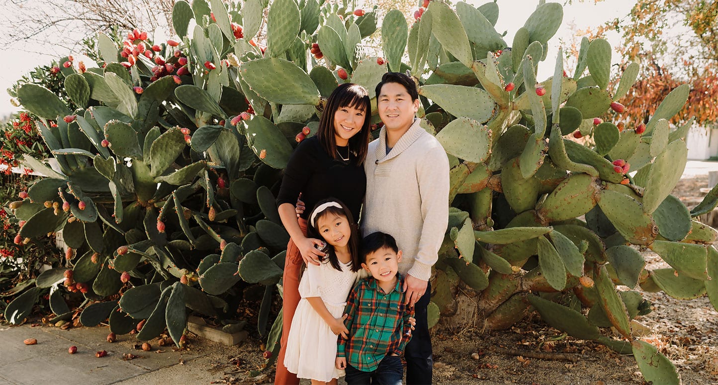 family-standing-in-front-of-large-cactus-during-photo-shoot-in-bay-area
